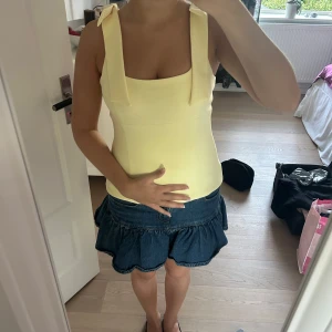 Gul linnetopp med rosetter från Zara - Supersöt ljusgul linnetopp från Zara med breda axelband och rosetter på axlarna. Toppen har en rak, figurnära passform och är perfekt för varma dagar. Materialet är mjukt och stretchigt. Pris kan diskuteras❣️