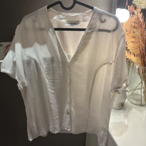 Vit kortärmad skjorta från Lindex - Säljer en snygg vit skjorta från Lindex med korta ärmar och v-ringning. På skjortan står det storlek 44 men skulle snarare säga att den passar L💞