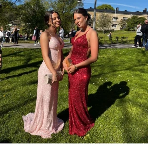 Glitter röd balklänning  - Säljer min balklänning från årets bal. Den är från dressrome på linne. Den är lång och glittrar. Nypris 4995 kroner. Den är i jättebra skick men lite paljetter har åkt av på, på vissa ställen är det områden  ( små) som det är utan. Kan skicka bild priv. och längst ner på klänningen men inget man tänker på. Är super nöjd och den är super bekväm!!