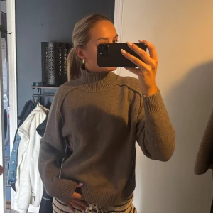 Beige/beun polotröja  - Säljer en beige polotröja med ribbad hög krage och muddar. perfekt till hösten!!! så så fin! knappt använd! är i storlek M men passar S