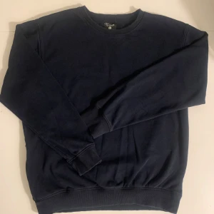 Sweatshirt från Clique - Säljer en stilren mörkblå sweatshirt från Clique i storlek XL. Tröjan har en klassisk design med rund hals och långa ärmar. 2st fickor.                            Perfekt för en avslappnad look. 🌀