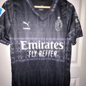 Svart AC Milan fotbollströja från Puma - Snygg svart AC Milan fotbollströja med Rafael Leao 10 på ryggen. Helt oanvänd tröja, skick 10/10. Hör av er vid funderingar!