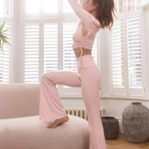 Ljusrosa träningsbyxor från Musera sport  - Snygga ljusrosa träningsbyxor från Musera sport med hög midja och utsvängda ben. Perfekta för en bekväm och stilren look under träningspasset. Materialet är mjukt och stretchigt för optimal rörelsefrihet.