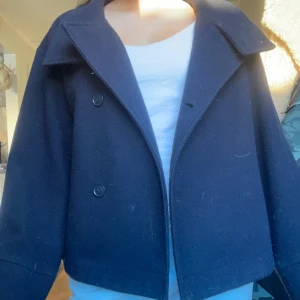 Mörkblå kappa - Snygg mörkblå kappa. Jättefint skick och inte använd mycket! Perfekt för våren!! PRIS KAN DISKUTERAS 