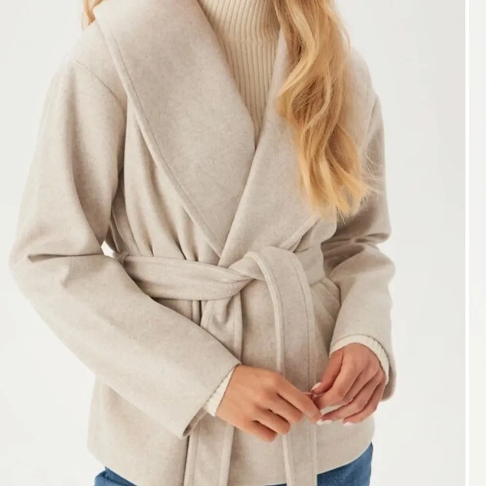 Snygg beige kappa med bälte och långa ärmar. Perfekt för höst och vår. Den har en stilren design med en omlott-look och är tillverkad i ett mjukt material. Använd fåtal gånger, som helt ny! Hör av er vid frågor❤️. Takit.