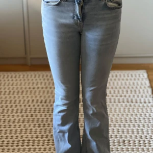Ljusblå bootcut jeans från Gina Tricot - Snygga ljusblå bootcut jeans från Gina Tricot. De har en klassisk femficksdesign och är tillverkade i ett bekvämt denimtyg. Perfekta för en avslappnad stil med en modern twist.