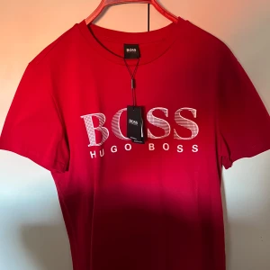 Röd t-shirt från Hugo Boss - Snygg röd t-shirt från Hugo Boss, helt ny. Storlek S fast passar även M då den är stor i storleken. 