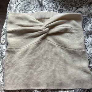 Beige stickad tubtopp från shein - Säljer en stilren beige stickad tubtopp med en elegant twistdetalj framtill. I storlek 36