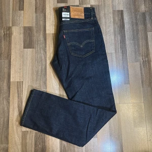 Levi's 511 jeans - Snygga Levi's 511 jeans i en klassisk mörkblå färg. De har en slim passform och är tillverkade i slitstarkt denim. Perfekta för en stilren look med den ikoniska Levi's-lappen på baksidan.
