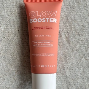 Glow Booster från Makeup Mekka - Glow Booster för alla hudtyper med acerolaextrakt, panthenol, vitamin E och granatäpple. Ger återfuktad och strålande hud. Vegansk och dermatologiskt testad. Perfekt att använda ensam eller med foundation för en lysande finish.