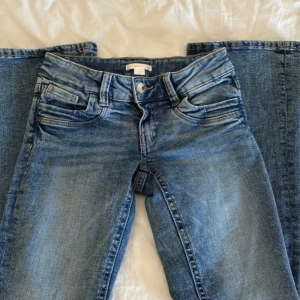 Blå jeans ifrån Gina Tricot - ”Low scandi bootcut jeans” ifrån Gina Tricot! Storlek 158. De är i super bra skick, då använda max 3 gånger. De har en liten defekt vid bakfickan men ingenting som man tänker på! (se sista bild). Skriv för mer bilder!
