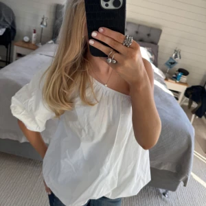 Vit offshoulder blus - Säljer en stilren vit offshoulder blus med puffiga ärmar. Perfekt för en avslappnad och chic look. Passar bra till både jeans och kjol. 