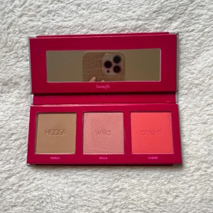 Chocoliciouse Cheeks Palette från Benefit - Säljer en fräsch ny Chocolicious Cheeks Palette från Benefit. Den innehåller en bronzer i nyansen Hoola, samt två rouge i nyanserna Willa och Cherri. Paletten har en praktisk spegel och kommer i en snygg röd förpackning. Endast testad vid 1 tillfälle.