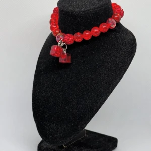 Rött pärlarmband med kubdetaljer - Snyggt rött armband med glittriga pärlor och unika kubformade detaljer. Perfekt för att ge en färgklick till din outfit. Halsbandet har en elastisk design för enkel användning.
