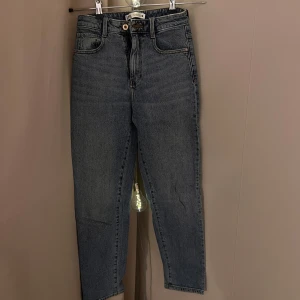 Zara jeansbyxor - Snygga jeansbyxor med hög midja och klassisk femficksdesign. Byxorna har en rak passform och stängs med dragkedja och knapp. Helt nya! 