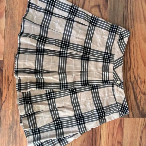 Kjol - Säljer då jag inte använder. Använd enstaka gånger och i ny skick. Snygg kortkjol med klassiskt rutigt mönster i beige och svart. Perfekt för en stilren look. Kjolen har en bekväm passform och är lätt att matcha med olika toppar. Kan mötas upp i Skåne, men annars står köparen för frakten! Skicka ett meddelande ifall du är intresserad innan du köper. Klicka INTE på köp nu! 