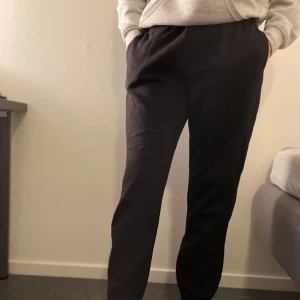 Svarta mjukisbyxor med resårmidja - Svarta mjukisbyxor med normal passform och resår i midjan. Byxorna har raka ben och är tillverkade i mjukt bomullsmaterial, perfekta för en avslappnad stil. De är sparsamt använda så i fint skick. Storlek S