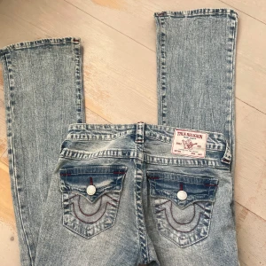 Blå True Religion jeans med slitningar - Säljer ett par blå jeans från True Religion köpta från Nelly.com säljer då dom inte kommer till användning dom är nästan aldrig använda och dom har inga skador eller liknande det är storlek 23. Skriv för frågor eller fler bilder och mått 