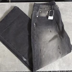 Gråsvarta Jeans Acne Studios - Säljer ett par gråsvarta jeans från Acne Studios med tvättad och sliten look. Byxorna har raka ben, klassiska fem fickor och silverfärgade nitar. Märkespatch bak i svart. Perfekta för dig som gillar en trendig och avslappnad stil.