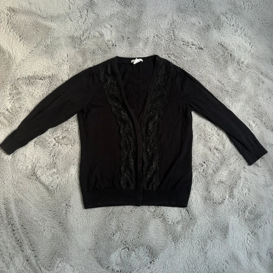 Svart kofta med spetsdetaljer