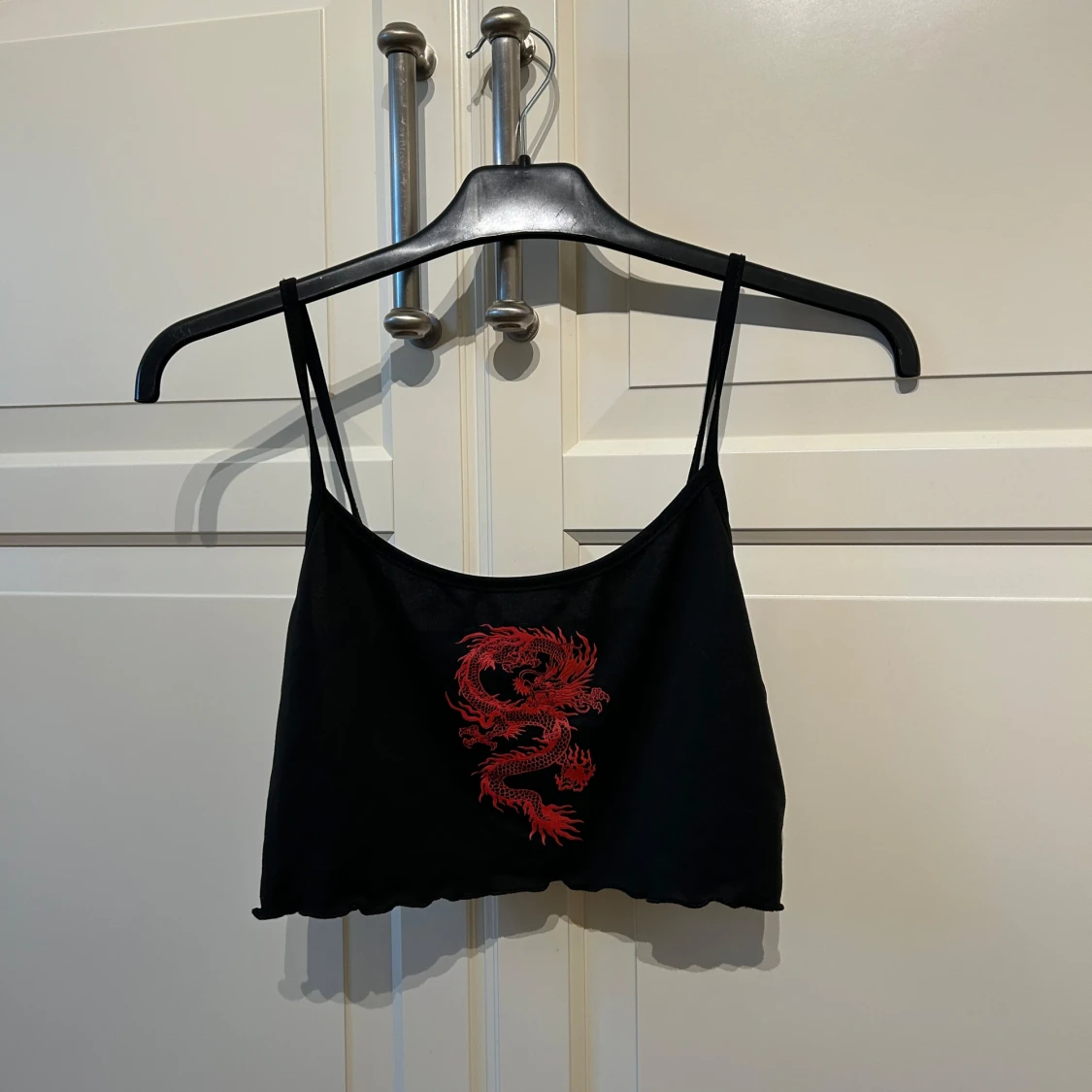 Svart croppad linnetopp med röd drake