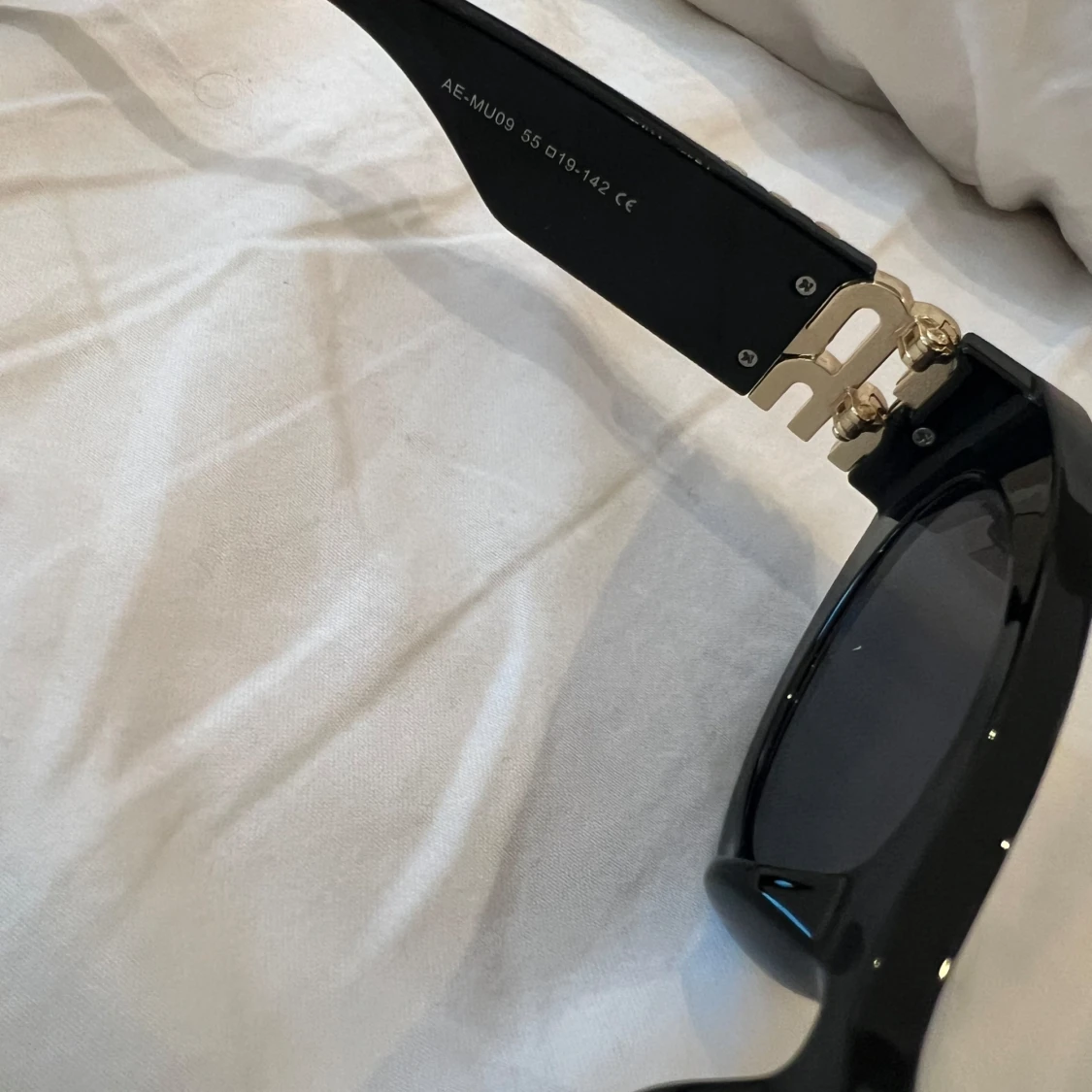 Svarta solglasögon från Miu Miu med guldiga detaljer - 2