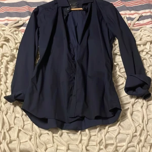 Mörkblå skjorta från Riley - Säljer en stilren mörkblå skjorta från Riley i super slim fit-modell. Skjortan har långa ärmar, klassisk krage och knäppning framtill. Perfekt för dig som gillar en smalare passform och enkel, tidlös stil.