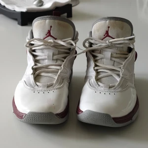 Vita Air Jordan basket skor med vinröda detaljer - Säljer nu mina basketskor (ändast använda inne) då de inte passar längre, de är i bra skick men lite missfärgade på plösen och i bakdelen men det går säkert att få bort om man tvättar dem ordentligt. Storlek 40. Tveka ej på att ställa frågor!