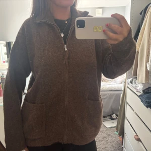 Brun stickad cardigan med dragkedja - Mysig brun stickad cardigan med dragkedja framtill och två stora fickor. Den är inte nopprig, kommer inte till användning❤️den är i storlek XL men sitter som en M-L på mig, jag själv har oftast M. Köpt för 800kr