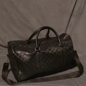 Svart Lv Weekendbag  - Snygg svart Lv bag med klassiskt rutigt mönster och både handtag och justerbar axelrem || pris kan diskuteras 