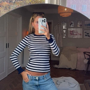 Randig långärmad tröja - Säljer en superfin randig tröja i marinblått och vitt. Den är långärmad och har en tight passform som framhäver figuren. Perfekt för både höst och vår! Tröjan är i bomull och känns riktigt skön mot huden. Passar perfekt till ett par jeans för en avslappnad look.