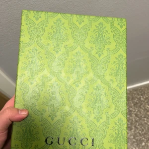 Svart keps från Gucci  - Säljer en svart keps från Gucci med klassiskt grönt och rött band på sidan. Kepsen har böjd skärm, justerbart spänne bak i skinn och diskret GG-mönster i tyget. Perfekt accessoar för en stilren look.