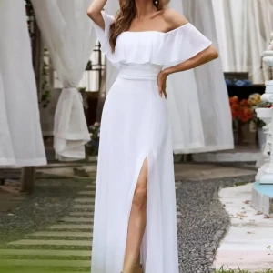 Vit offshoulder långklänning med volang - Superfin vit långklänning med offshoulder och volang upptill. Klänningen har en hög slits framtill och markerad midja för en snygg siluett. Perfekt för sommarens alla tillfällen.