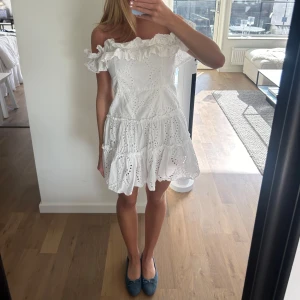 Vit offshoulder klänning med volang och broderad spets - Säljer en eftertraktad super fin kort klänning💕passar perfekt till student,midsommar eller konfirmation💕klänningen är in princip helt ny💕