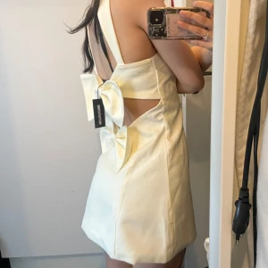 Ny PLT klänning - Endast testad med lapp kvar, från PrettyLittleThing med öppenrygg och rosetter🩷Fin till studenten, mer i en krämvit färg