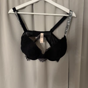 Svart spets-bh från Victoria's Secret - Säljer en svart bh från Victoria's Secret med spetsdetaljer och glittriga axelband. Bh:n har dekorativa band framtill och meshpartier som ger en lyxig känsla. Perfekt för dig som vill ha något extra snyggt under kläderna. Aldrig använd. 
