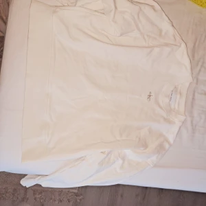 Vit sweatshirt från Calvin Klein Jeans - Säljer en stilren vit sweatshirt från Calvin Klein Jeans med diskret logga på bröstet. Tröjan har rund halsringning och långa ärmar. Perfekt för en clean och enkel look.