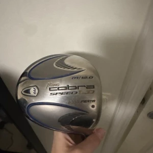 King Cobra Speed LD M Driver 12.0° - Golfklubba King Cobra Speed LD M driver med 12.0° loft. Skaftet är blått med regular flex och väger 50g. Klubbhuvudet är i silver och svart med blå detaljer. Perfekt för dig som vill ha extra längd och kontroll på utslagen.