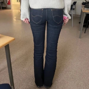 Lågmidjade lee jeans  - Säljer ett par mörkblå lågmidjade bootcut jeans från Lee, superfint skick. Dem är uppsydda hos skräddare för mig som är 162. Nypris 900kr 
