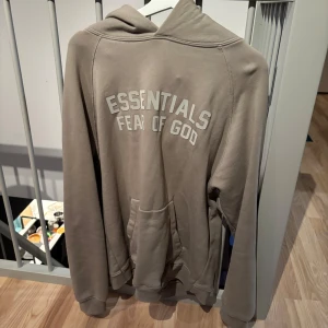 Essentials tracksuit  - Beige färgad essentials tracksuit där både koftan och byxorna ingår. Är i bra skick och i storlek M på båda plaggen 