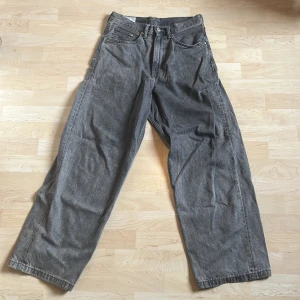Grå baggy jeans från H&M - Säljer ett par gråa baggy jeans från H&M med loose fit. Jeansen har klassisk femficksdesign, raka ben och normal midja. Perfekta för en avslappnad och trendig stil.