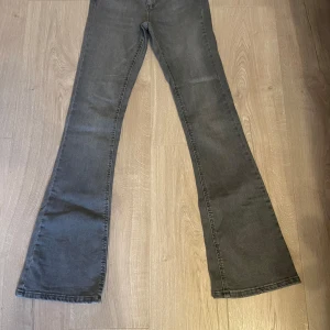Grå bootcut jeans från ONLY - Säljer ett par helt oanvända gråa bootcut jeans från ONLY. Jeansen har klassisk femficksdesign och är tillverkade i denim. Perfekta för dig som gillar en lite utsvängd siluett och vill ha ett par stilrena jeans i garderoben.