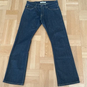 Levi's 512 Bootcut Jeans W34 L34 - Mörkblå Levi's 512 bootcut jeans med klassisk femficksdesign. Byxorna har normal passform och är tillverkade i slitstarkt denim. Perfekta för dig som gillar en tidlös jeansstil med lite utsvängda ben.