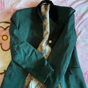 Dressyr kavaj  - Jättesnygg mörkgrön dressyr  kavaj med mönster i, säljer för att den inte kommer till användning. Fick den av min syster som inte visste att det var just en dressyr kavaj.