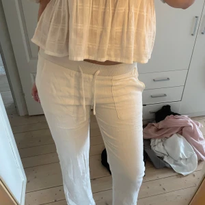 Vita linnebyxor med dragsko - Säljer ett par jätte snygga vita linnebyxor med bred resår i midjan och dragsko. Byxorna har raka ben och stora fickor framtill💞ser exakt lika dana ut som de från alobha label. Linnebyxorna har två lager med tyg och är därför inte genomskinliga😊 litet hål som lätt går att fixa och som knappt syns pga att de är två lager tyg💓💓