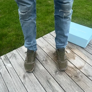 Olivgröna sneakers från Philippe Model - Säljer ett par olivgröna sneakers från Philippe Model med vita och grå detaljer. Skorna har snörning och en platt sula. Perfekta för dig som vill ha en stilren och trendig look. Priset är inte hugget i sten skriv vid intresse!