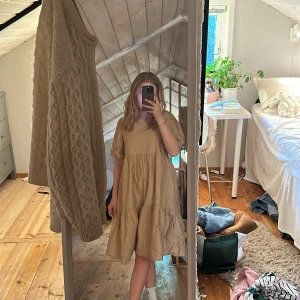 Beige volangklänning med v-ringning - Säljer en beige klänning med volanger. Klänningen har korta ärmar och en lös passform Perfekt för en mer festlig lok eller bara till sommaren 