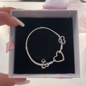Silver armband med hjärtan från Pandora - Säljer ett stilrent silver armband från Pandora med flera hjärtformade detaljer.  Kommer i originalförpackning. Original pris är runt 1500kr.
