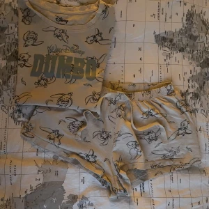 Disney Dumbo shorts & T-shirt  - Beiga shorts & T-shirt. Shorts med elastisk midja och ett gulligt Dumbo-tryck över hela tyget. Disney pyjamas sett. Storlek (34-36)