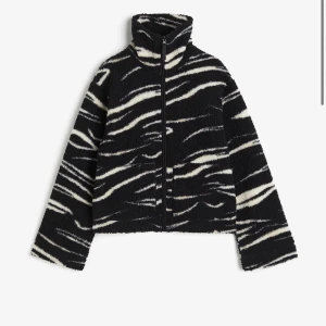 Svart och vit teddyjacka med zebramönster - Jättefin teddyjacka i svart och vitt med zebramönster och hög krage. Jackan har dragkedja framtill och långa ärmar. Super skön, helt slutsåld på hemsidan💘💘